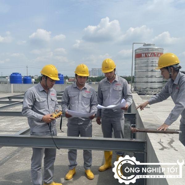 Nhóm kỹ sư Công Nghiệp Tốt đang khảo sát công trình bồn nước: đo tải trọng, kiểm tra khung, kiểm tra mái tôn, mang đồng phục kỹ thuật.